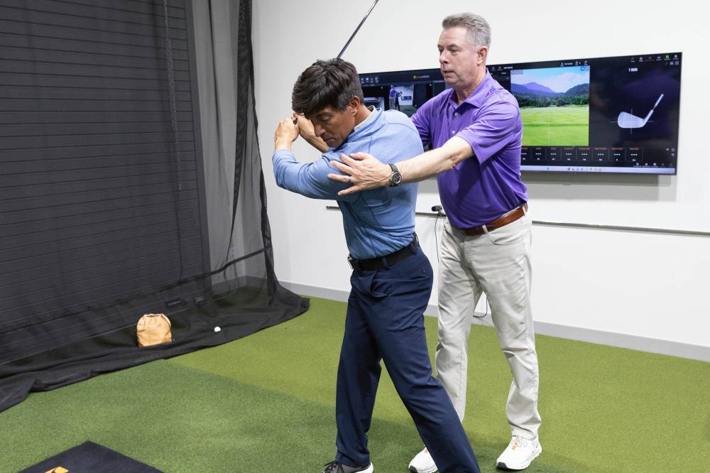 Head Coach Tim Cusick helps a golfer improve his swing at the PGA Coaching Center. (Courtesy PGA Coaching Center)